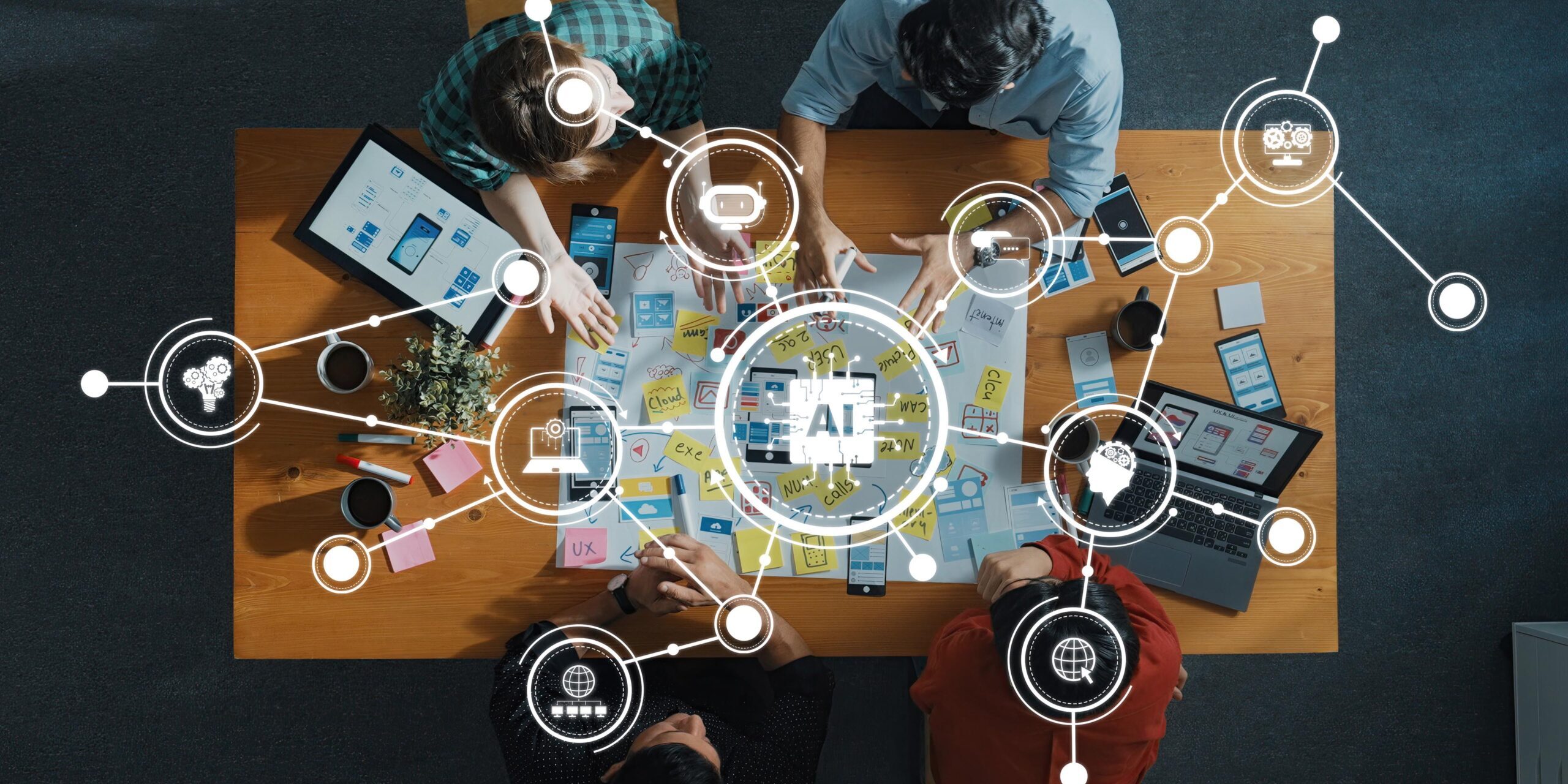 A top-down view of a collaborative team working on AI technology development with digital tools on a wooden table, showcasing creativity and innovation in professional settings. Amity