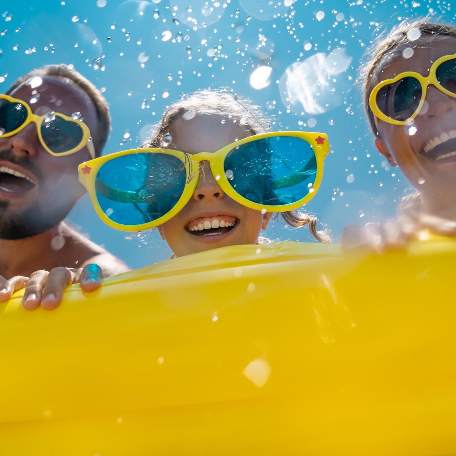 Family having fun on summer vacation. People jumping in swimming pool. Active lifestyle concept. Spring break!